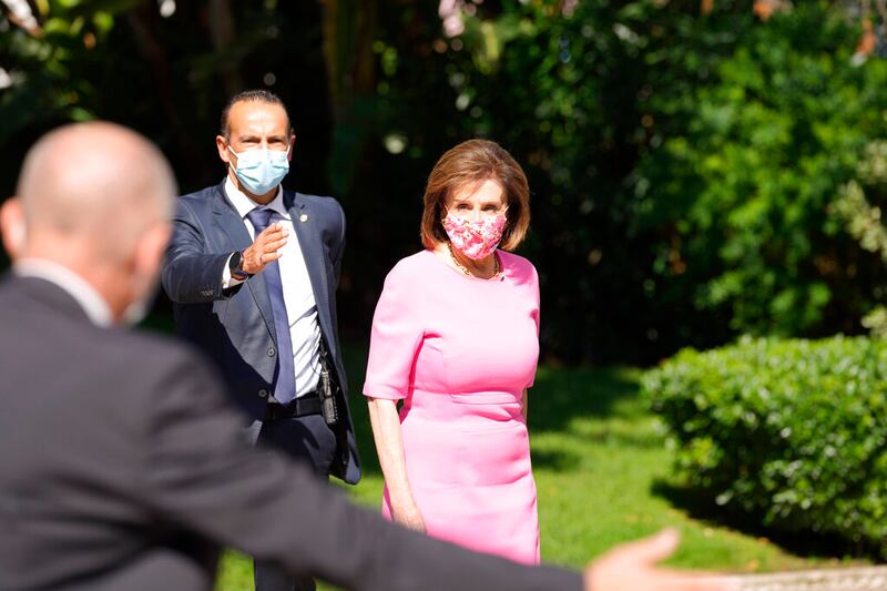 Speaker of the House Nancy Pelosi is directed by security officers in Lisbon, Portugal. Pelosi’s visit to a church in Rome was interrupted by protesters.