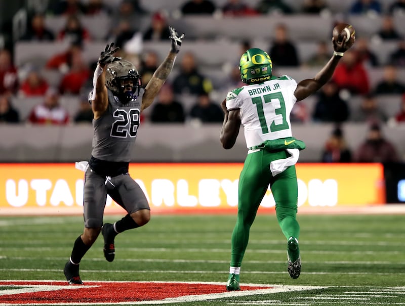 Utah Utes safety Brandon McKinney tries to defend Oregon Ducks quarterback Anthony Brown.