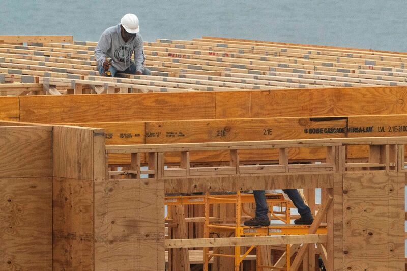 Builders work on a four-story, 45-unit condominium building under construction on Tuesday, May 31, 2022, in Portland, Maine.