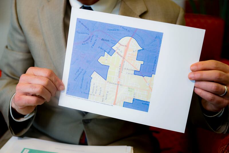 FILE - In this Thursday, April 11, 2019, file photo David Niven, a professor of political science at the University of Cincinnati, holds a map demonstrating a gerrymandered Ohio district in Cincinnati. The Supreme Court said, by a 5-4 vote on Thursday, Ju