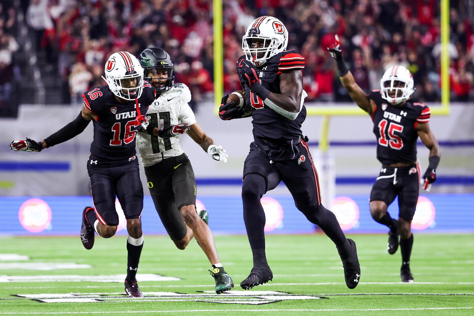 Utah’s Devin Lloyd, wearing black, returns an interception