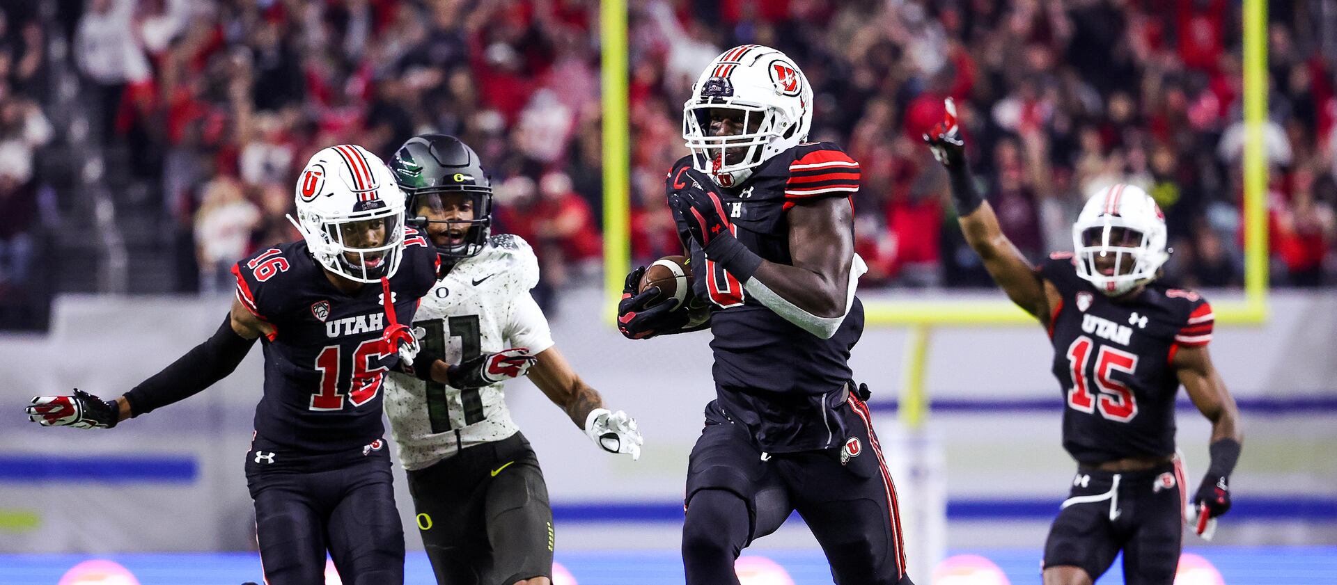 Utah’s Devin Lloyd, wearing black, returns an interception