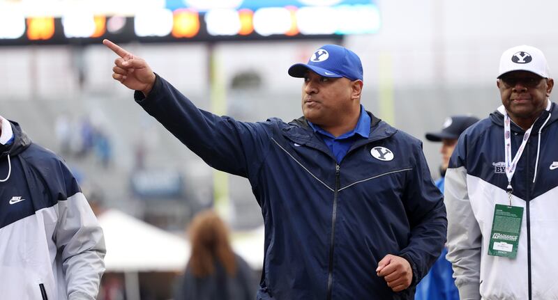 BYU head coach Kalani Sitake waves to fans as he heads to the locker room at halftime of the Independence Bowl.