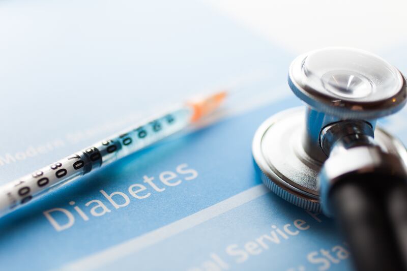 A stethoscope and a syringe on a diabetes test.