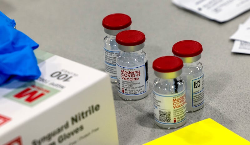 Vials of Moderna’s COVID-19 vaccines sit on a table.