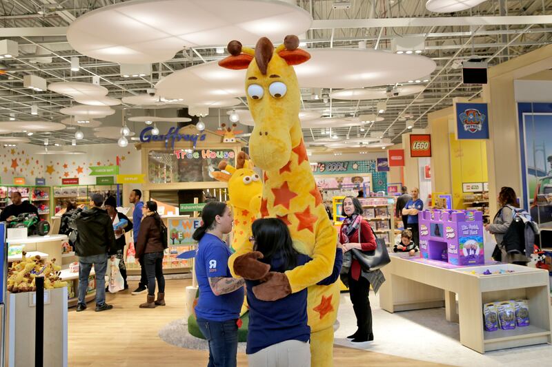 In this Dec. 9, 2019, file photo a girl hugs the Toys R Us mascot, Geoffrey, at the new store at a mall in Paramus, N.J The only two Toys R Us stores that opened in November 2019 as part of a small U.S. comeback attempt by the iconic toy chain have now closed.