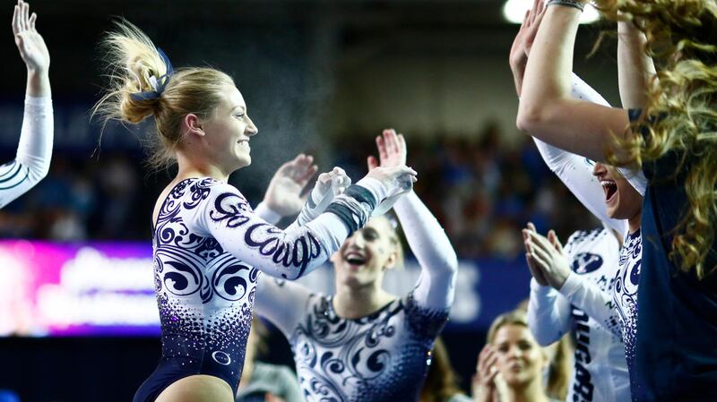 Shannon Hortman Evans (left) celebrates with teammates after her bars routine against Southern Utah.