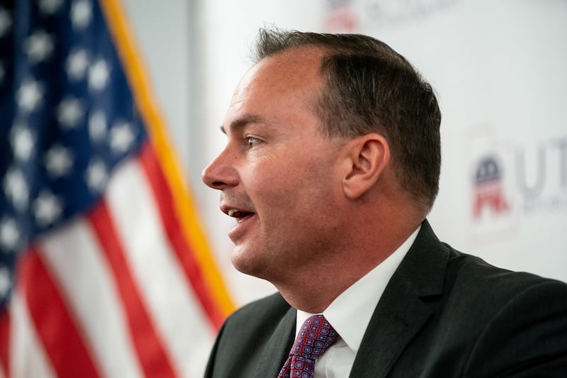 Sen. Mike Lee speaks in front of an American flag.