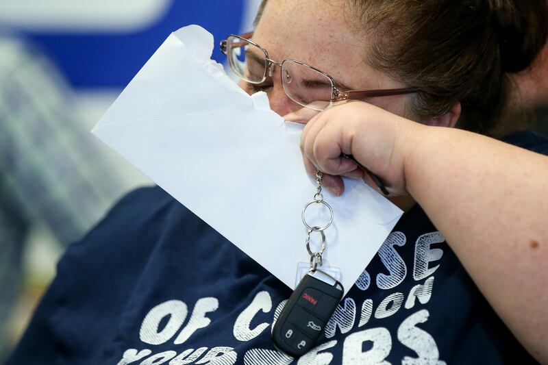 Darlene Lefevre wipes her eye while holding the key to a 2015 Chrysler 200 that was donated to her at Higgins Body and Paint in West Valley City on Wednesday, June 27, 2018. Geico and Higgins Body and Paint, along with other organizations, teamed up to do
