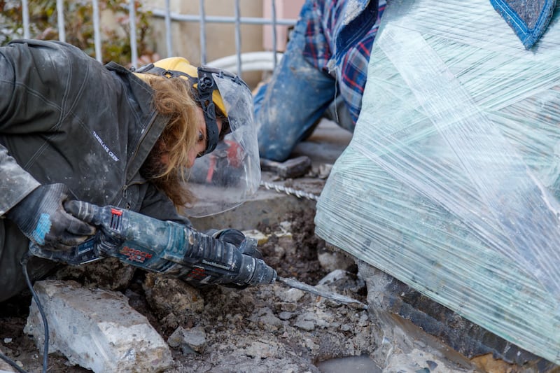 An expert art handler chisels concrete away from a 2,500-pound petroglyph created by ancestors of the Northwestern Band of the Shoshone Nation on Monday, December 8, 2025, in Tremonton, Utah.