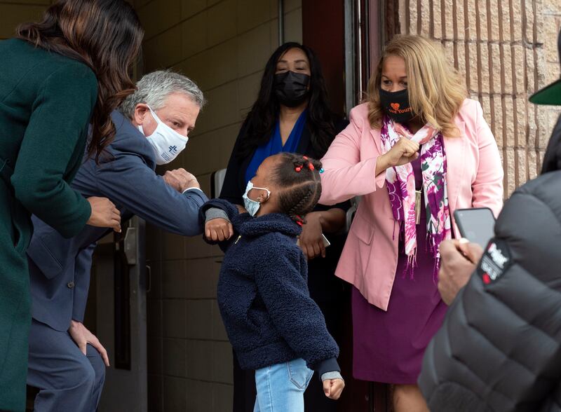 Mayor Bill de Blasio and Schools Chancellor Meisha Porter greet a student arriving at Phyl’s Academy in the Brooklyn borough of New York.