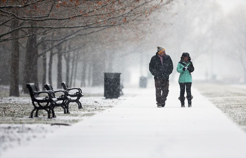 Corey Sautebin and Rachel Lovato take a walk at Liberty Park in Salt Lake City as snow moves into the Wasatch Front on Saturday, Jan. 6, 2018.