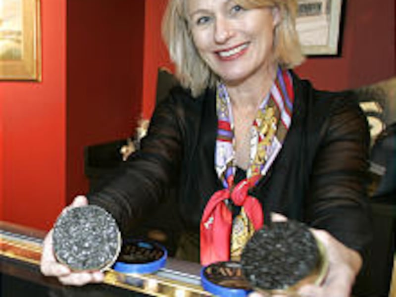 Betsy Sherrow, president of the gourmet retail store Seattle Caviar Co., holds tins of beluga caviar, left, and white sturgeon caviar.